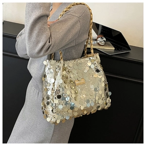 Detail of gold sequin tote bag showing the woven handle and leather brand tag