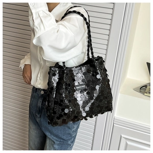 Detail of black sequin tote bag featuring a woven strap and Fashion & Bags logo patch
