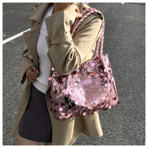 Detail of dark pink sequin tote bag showing metallic texture and braided handles