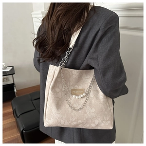Detalle de bolso shopper grande con estampado floral, cadena plateada y perlas