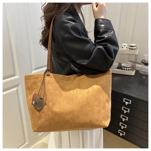 Side view of large vintage brown suede tote bag worn by a model in a modern interior