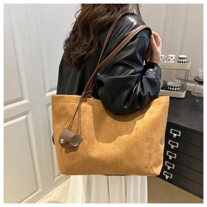 Detail view of large brown suede tote bag with leather strap and mini coin pouch accessory
