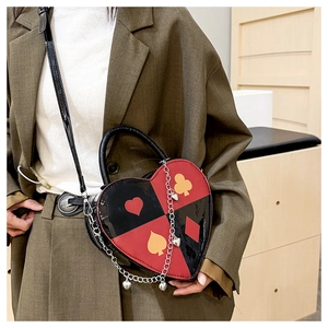 Détail du sac à bandoulière en forme de cœur avec motif poker rouge et noir et chaîne