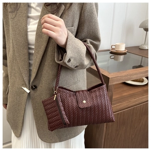 Detail of woven leather tote bag in burgundy with matching hanging coin purse accessory