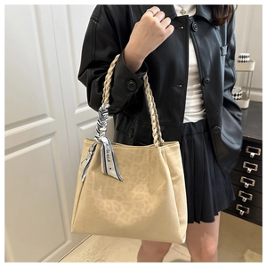 Detail of beige leopard print tote bag with woven handles and Paris pattern scarf