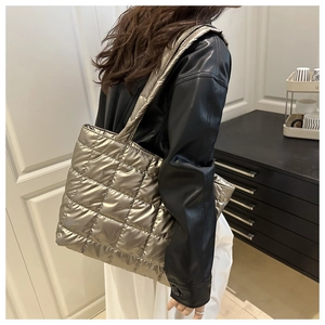 Quilted metallic tote bag shown on shoulder with large capacity and glossy finish