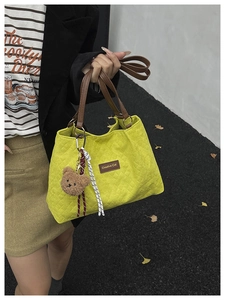Borsa shopper trapuntata verde con manici marroni e ciondolo orsetto per uso quotidiano.