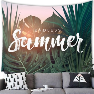 Detail of tropical palm leaves tapestry with Endless Summer text above a grey sofa