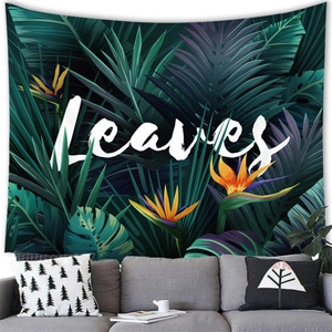 Detail of tropical palm and monstera leaves wall tapestry behind a living room sofa