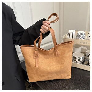 Detail view of brown suede tote bag handle featuring an adjustable metal needle buckle