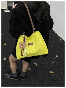 Elegante borsa tote trapuntata gialla da donna con grazioso ciondolo orsetto e cinturino in pelle.
