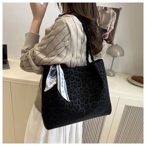 Gros plan sur le sac léopard avec poignées tressées et détail du foulard Paris