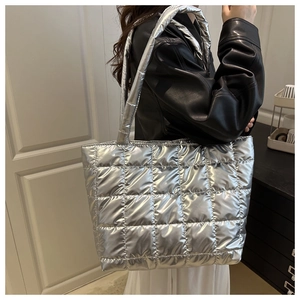 Detail of silver metallic quilted tote bag with square stitching and glossy puffer texture