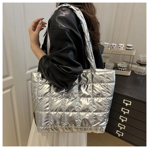 Detailed view of silver quilted tote bag featuring metallic finish and soft padded texture