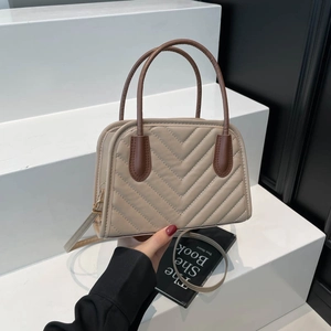 Quilted beige crossbody bag with V-shaped stitching and dark brown top handles