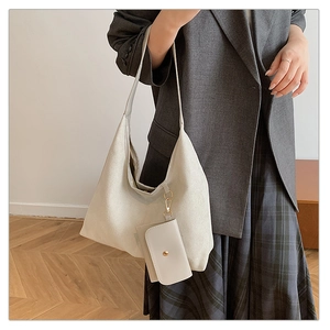 Detail view of large cream tote bag with matching coin purse and wide shoulder strap