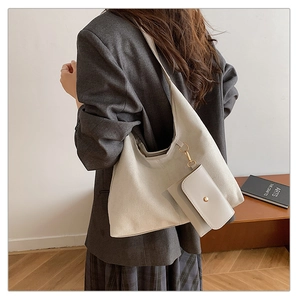 Detail of off-white suede hobo bag featuring a matching zipper pouch and golden hardware