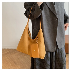 Detail view of mustard yellow suede tote bag with matching snap-button small coin purse