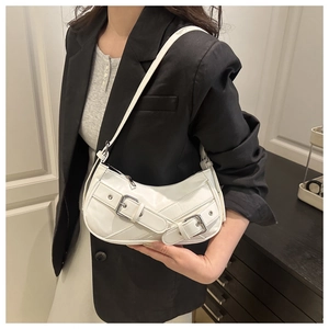 Close-up of white faux leather underarm bag with silver buckles and a crescent shape