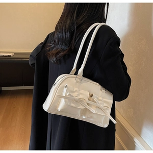 Detail of cream balletcore shoulder bag featuring elegant bow accents and dual pockets