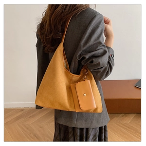 Detail of suede tote bag in ginger yellow with matching detachable pouch accessory