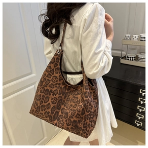 Adjustable brown shoulder strap with silver eyelets on a leopard print tote bag