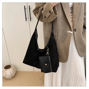Detail of black suede tote bag with matching small coin purse on a stylish shoulder strap