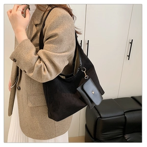 Detail of black suede tote bag with mini coin purse attachment and gold snap button