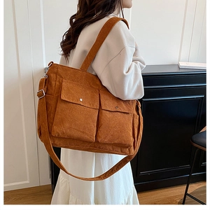 Detail of caramel corduroy tote bag showing large front pockets and striped texture