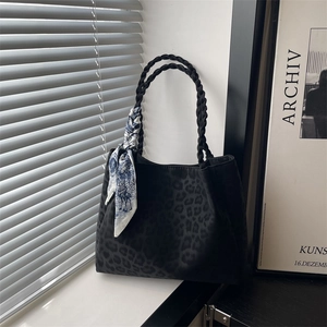 Black leopard embossed tote bag with braided handles and floral silk scarf accessory