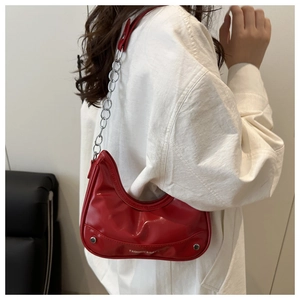 Detail of red patent leather crescent bag with silver chain and Fashion & Ba text logo
