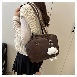 Detail of vintage brown leather bowling bag with silver hardware and cloud pendant