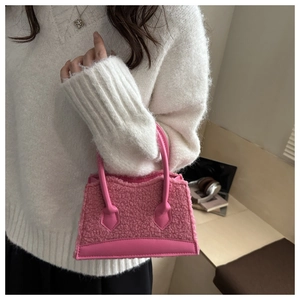 Detail of pink faux fur crossbody bag featuring a smooth leather handle and plush texture