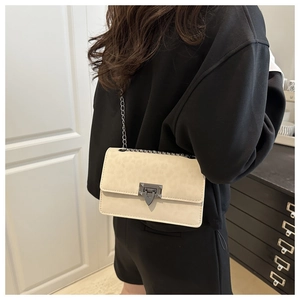 Detail of cream chain crossbody bag featuring V-shaped metal buckle and leopard texture