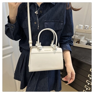 Detail of white leather tote with knotted handles and detachable shoulder strap