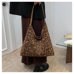 Detail of large leopard print tote bag showing soft velvet texture and wide shoulder strap