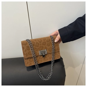 Detail of leopard print suede shoulder bag with silver chain strap and metal clasp