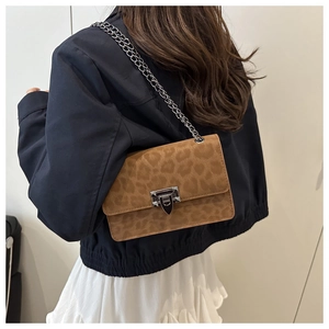 Leopard print crossbody bag with silver chain strap shown on model over the shoulder