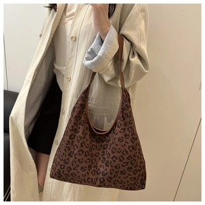 Close-up of a large leopard print tote bag worn on shoulder for a retro fashion look