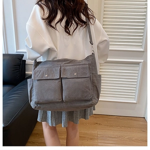 Detail view of grey corduroy tote bag featuring dual front pockets and adjustable strap
