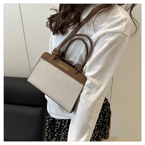 Detail of canvas and leather shoulder bag with gold 'FASHION BAG' embossing