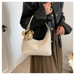 Detail of off-white lychee grain leather hobo bag with printed silk scarf on handle
