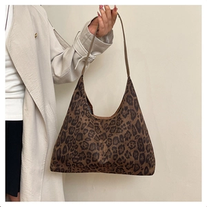 Detail of leopard print velvet tote bag worn with a stylish autumn trench coat