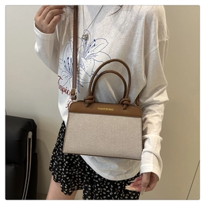 Detail of two-tone brown leather and beige fabric tote bag with Fashion Bag text