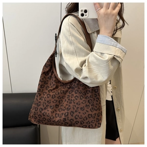Detail shot of leopard print tote bag with brown straps in a lifestyle mirror selfie