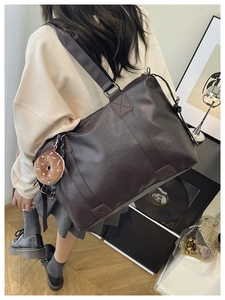 Détail du grand sac cabas en similicuir marron avec breloque peluche et bandoulière