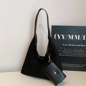 Minimalist black faux suede shoulder tote bag with a small matching purse on white background