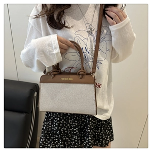Detail of canvas shoulder bag with brown leather trim and Fashion Bag lettering