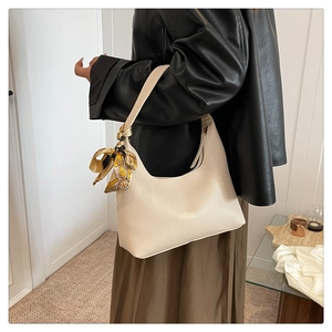 Detail of cream lychee texture leather hobo bag with floral scarf on shoulder strap