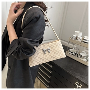 Dettaglio borsa a spalla beige con stampa M marrone e fibbia a fiocco in metallo argento